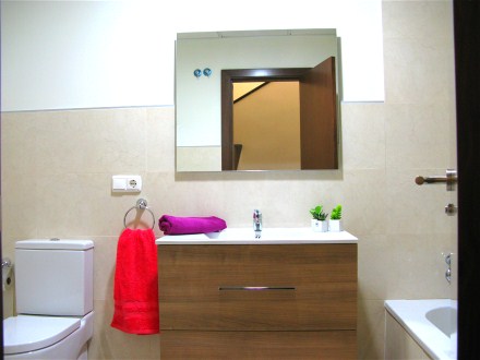 Das Bad hat eine Wanne und einen Waschtisch mit groem Spiegel