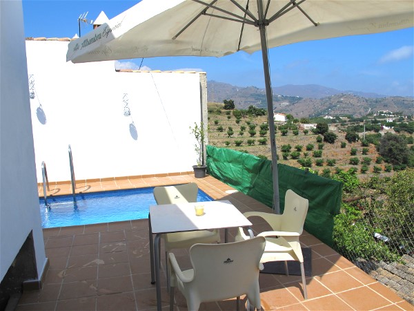 Poolterrasse mit Tisch und Sonnenschirm