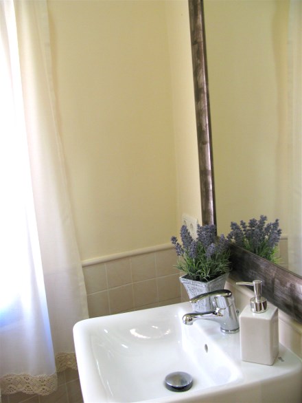 Das Bad hat eineDusche und ber dem Waschtisch hngt ein grosser Spiegel