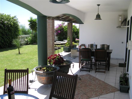 Auf der �berdachten Terrasse steht ein grao�e Teakholz Tisch